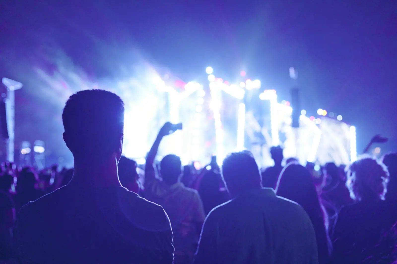People watching a stage lit in purple